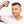 Man with short straight brown hair and white sideburns using the spray applicator
